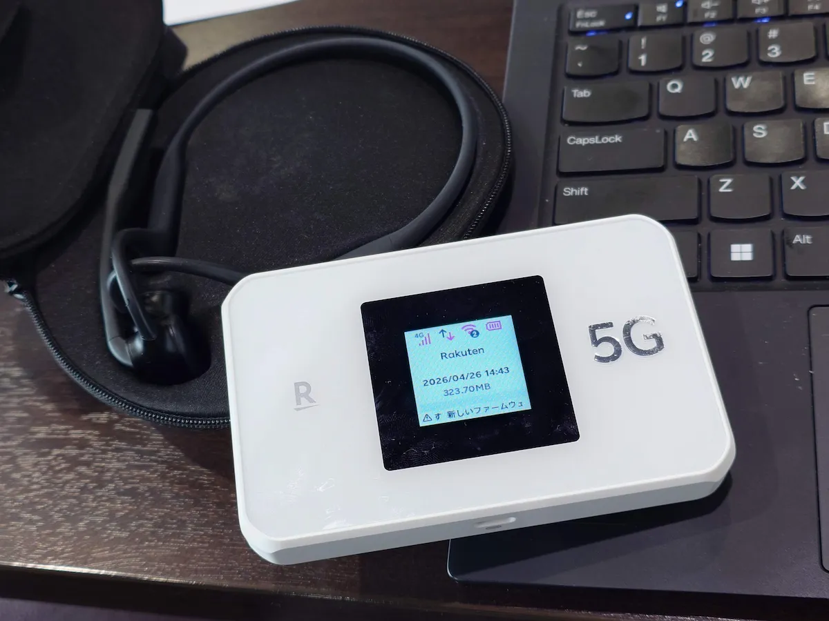 Rakuten WiFi Pocket 5Gをノートパソコンと並べて作業中の様子（編集部撮影）